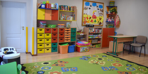 wyposażenie sali przedszkolnej- meble, dywan, biurko z krzesłem, drzwi