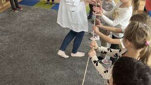 dzieci rozciągają linę, żeby sprawdzić jak długie jest jelito
