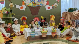 dzieci siedzą na podłodze przebrane w stroje związane ze świętami wielkanocnymi